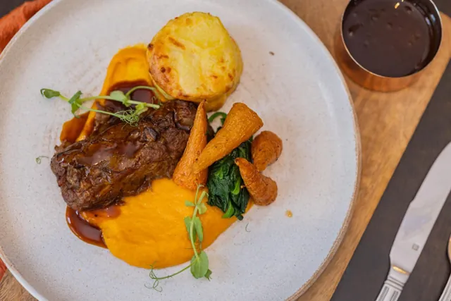 A plated main course with vegetables and a potato accompaniment from DishLab’s menu development work