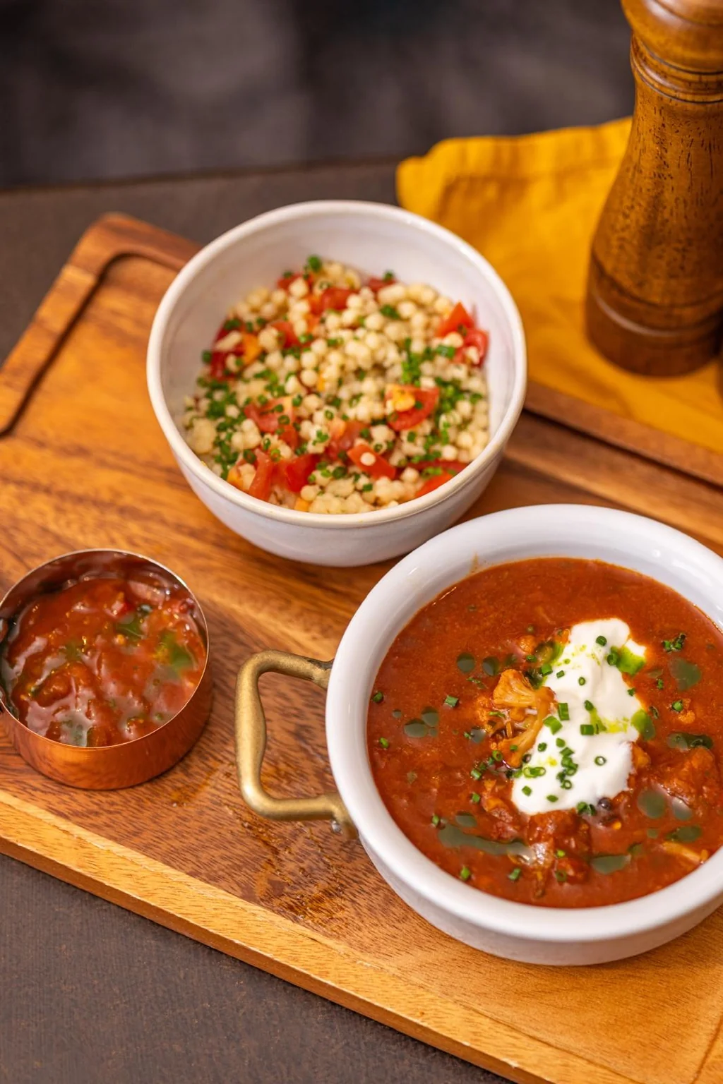 Rich tomato-based dish with a grain salad and accompaniments