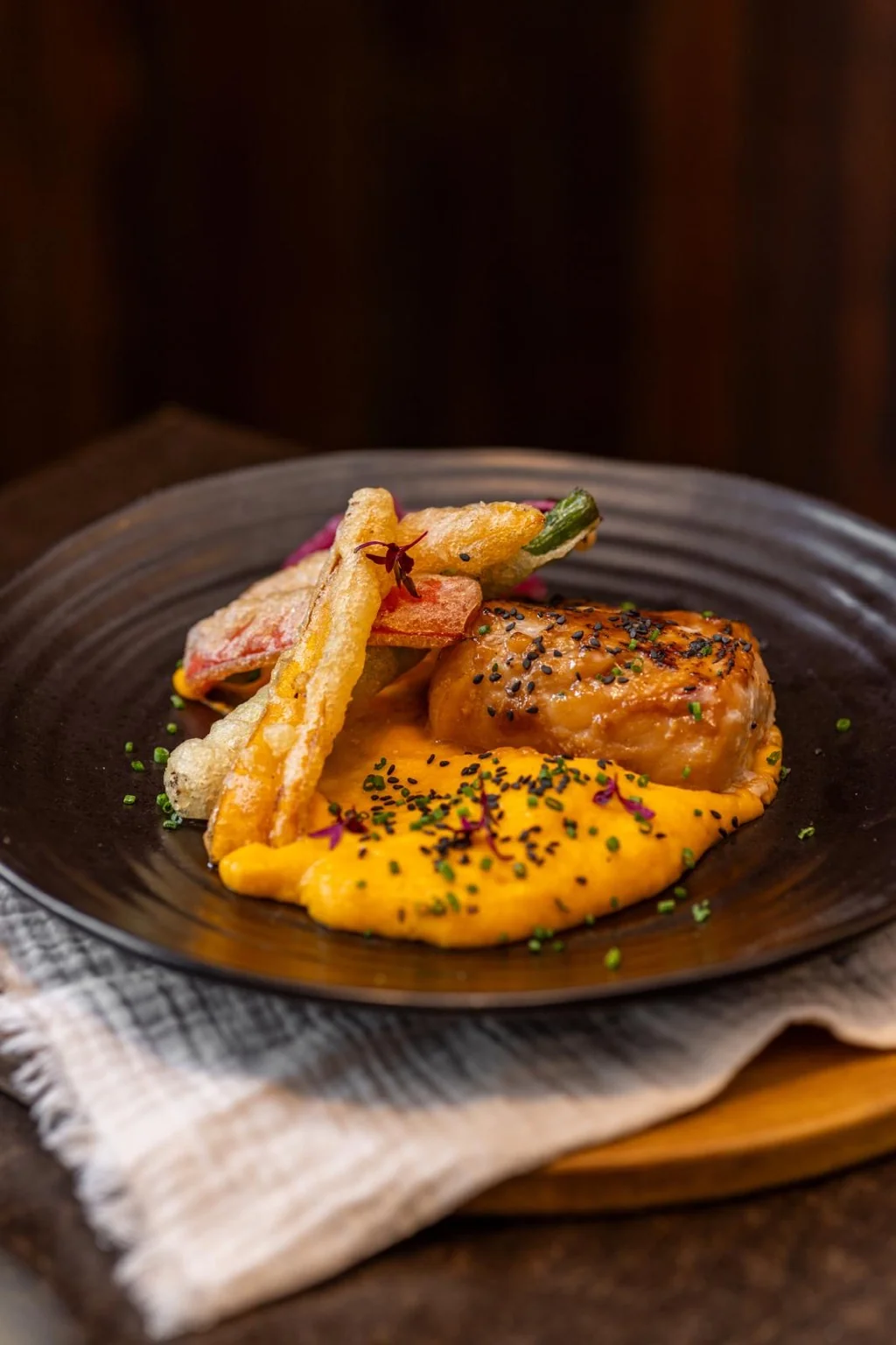 A premium plated fish dish with colourful accompaniments