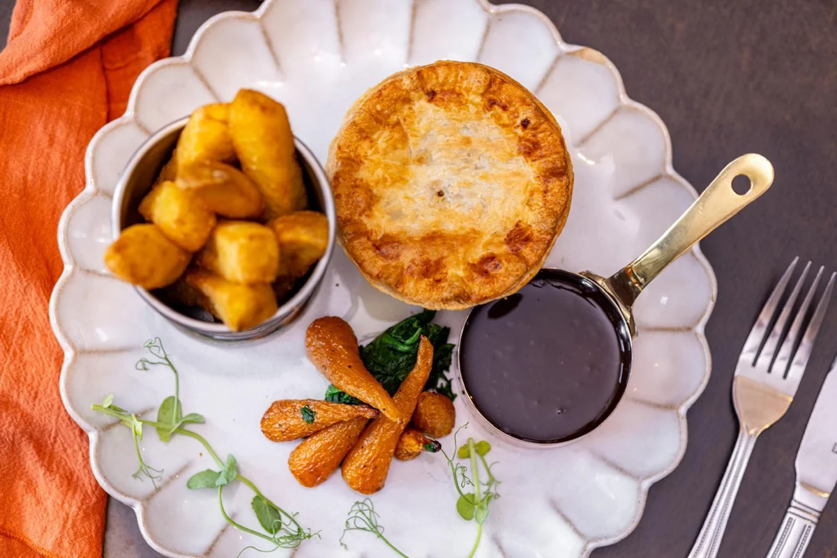 Individual golden pie with potatoes, vegetables and gravy
