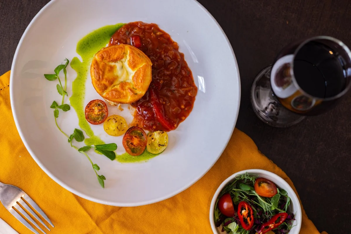 Golden soufflé with tomatoes, herb oil and a side salad