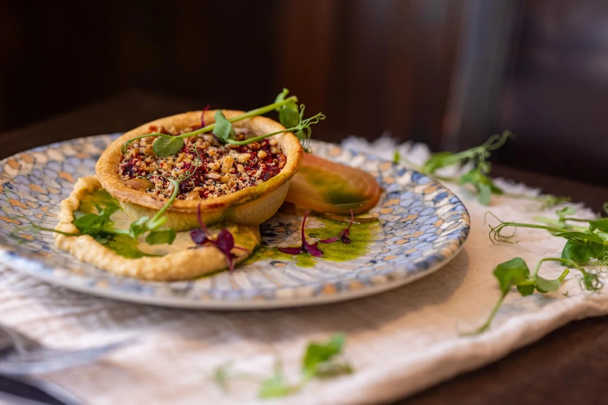 Savoury tart with a crumb topping, purée and fresh shoots